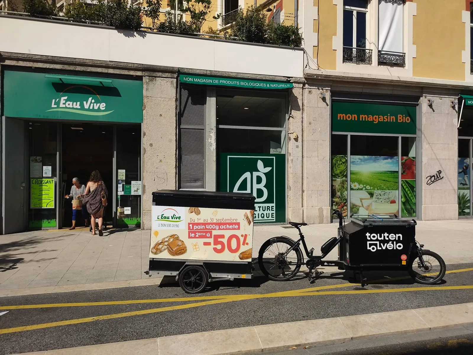 Remorque publicitaire LCDG stationnée devant la vitrine d'un magasin bio