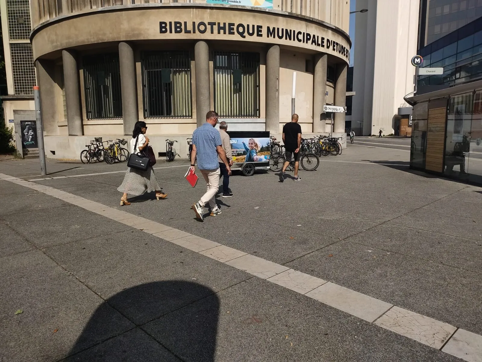 Vélo publicitaire LCDG devant la bibliothèque municipale, sur un parvis passant
