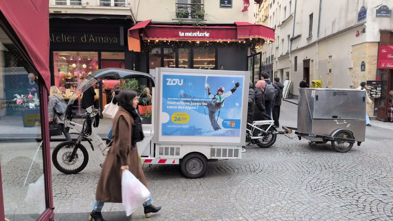 Remorque publicitaire LCDG stationnée devant un commerce dans une rue parisienne