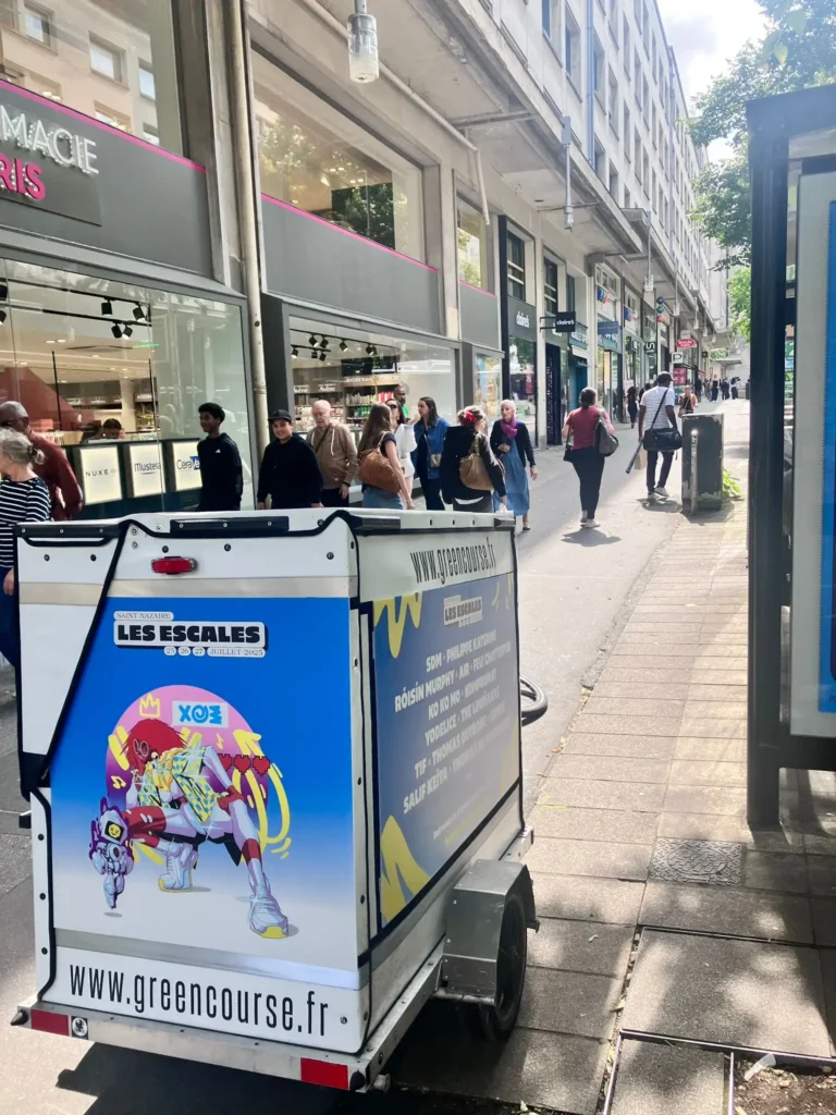 Support publicitaire mooh dans une rue animée du centre-ville de Nantes.