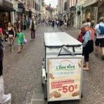Vélo publicitaire arrêtant les passants dans la rue.