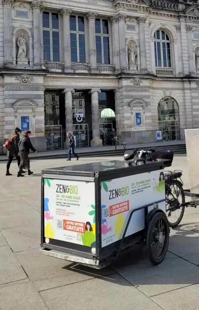 Campagne ooh, avec un vélo publicitaire pour un Salon dans un centre-ville.