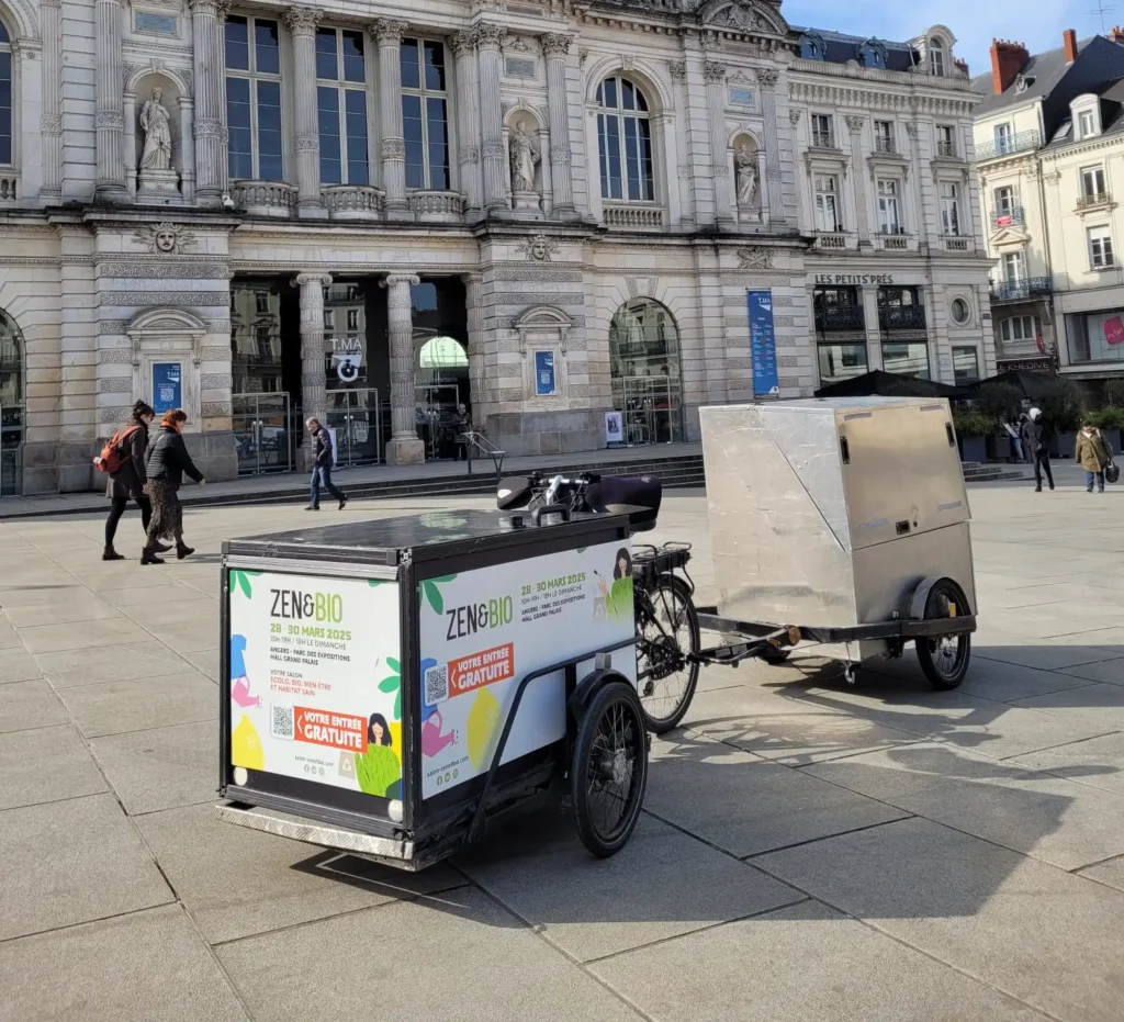 Campagne ooh, avec un vélo publicitaire pour un Salon dans un centre-ville.